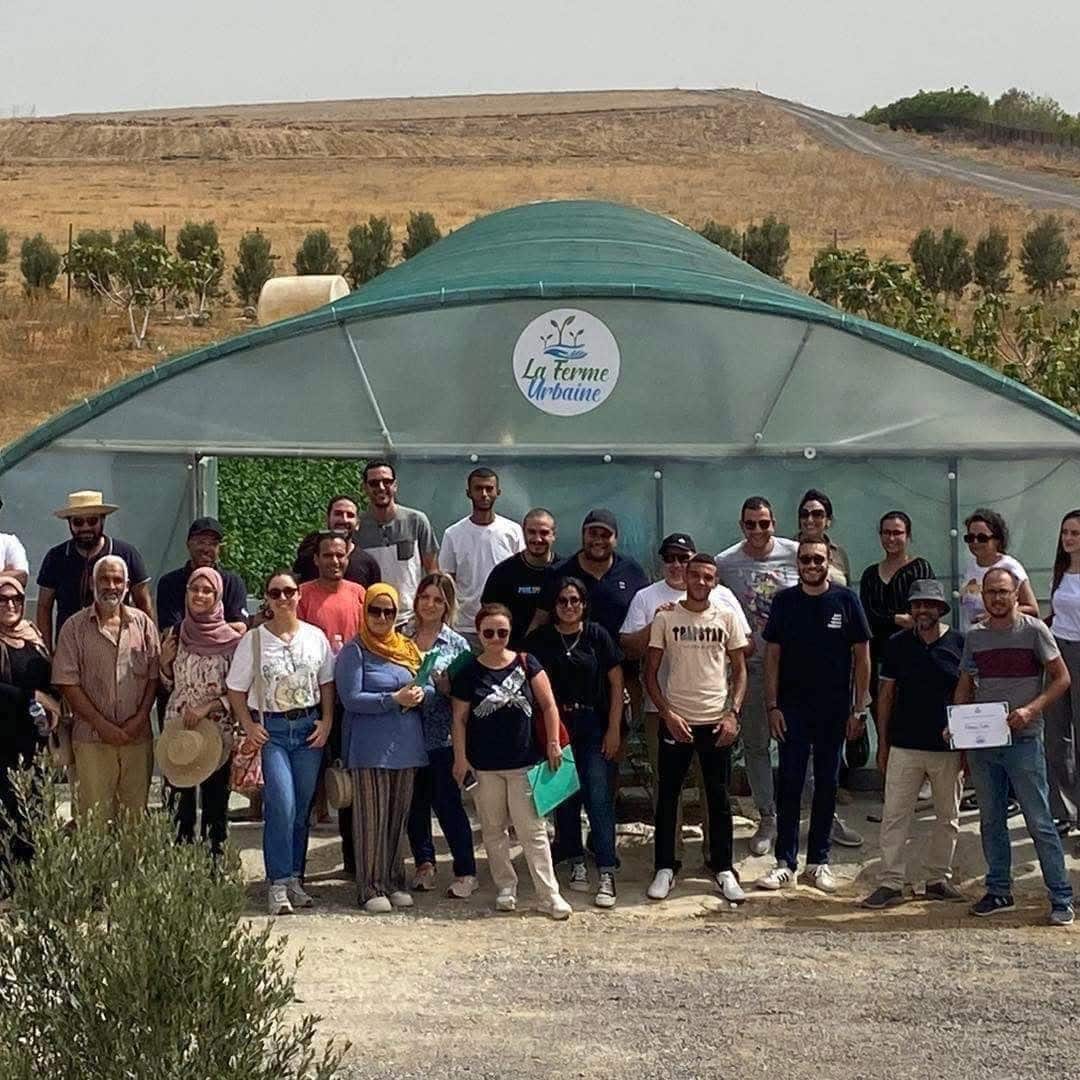 The team and participants gathered in front of a La Ferme Urbaine greenhouse in Tunisia